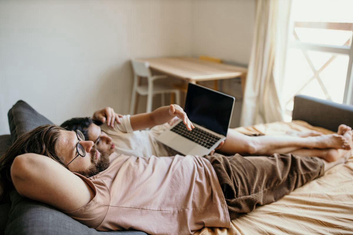 A man watching a video on his laptop while relaxing at home